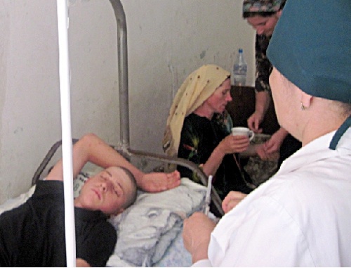 Teenager beaten by militiamen in the district hospital. His mother Aishat Guseinova is behind him. Dagestan, Shamil District, July 2010. Photo by the HRC "Memorial": www.memo.ru Teenager beaten by militiamen in the district hospital. His mother Aishat Guseinova is behind him. Dagestan, Shamil District, July 2010. Photo by the HRC "Memorial": www.memo.ru