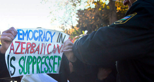 A police officer tries to take away a poster saying "Democracy in Azerbaijan is surpressed" from a protestor. Baku, 2012. Photo by Aziz Karimov for the "Caucasian Knot". A police officer tries to take away a poster saying "Democracy in Azerbaijan is surpressed" from a protestor. Baku, 2012. Photo by Aziz Karimov for the "Caucasian Knot".