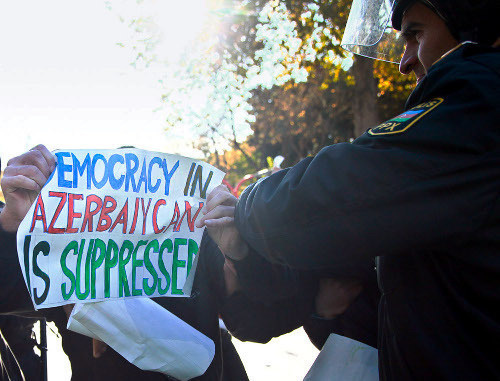A police officer tries to take away a poster saying "Democracy in Azerbaijan is surpressed" from a protestor. Baku, 2012. Photo by Aziz Karimov for the "Caucasian Knot". A police officer tries to take away a poster saying "Democracy in Azerbaijan is surpressed" from a protestor. Baku, 2012. Photo by Aziz Karimov for the "Caucasian Knot".