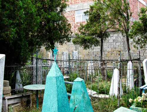 Obelisks in the "Russian Cemetery" against a background of a newly-erected building. Makhachkala, August, 2013. Photo: prosto_gusev@livejournal.com Obelisks in the "Russian Cemetery" against a background of a newly-erected building. Makhachkala, August, 2013. Photo: prosto_gusev@livejournal.com