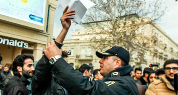Baku, The Fountain Square, December 8, 2013. The policeman trying to prevent a silent protest against rise in fuel prices. Photo by Aziz Karimov for the ‘Caucasian Knot’. Baku, The Fountain Square, December 8, 2013. The policeman trying to prevent a silent protest against rise in fuel prices. Photo by Aziz Karimov for the ‘Caucasian Knot’.