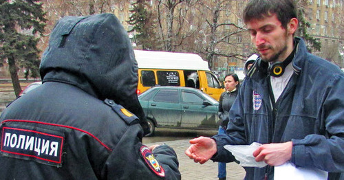 Police officer checking document of activist Yury Trotsenko during solo picket. Volgograd, March 7, 2015. Photo by Vyacheslav Yaschenko for the ‘Caucasian Knot’. 