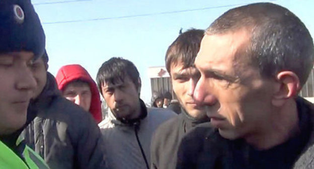 Andzor Akhokhov talking to law enforcer durign the action against the Sochi Olympic Games. Screenshot from video "NO SOCHI. Cherkessia. Kabarda. 07.02.14" posted on YouTube by Cherkes Cherkesia, https://www.youtube.com/watch?v=SiVpnRFrurc&feature=youtu.be