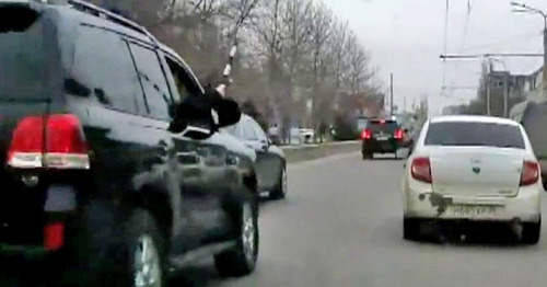 The security guard from the jeep of the convoy of the head of the republic Ramazan Abdulatipov beating the side mirrors of the surrounding cars with a police truncheon. Makhachkala, April 1, 2015. Screenshot of a video  by the user MishkaKG http://www.youtube.com/watch?v=GZzEzujUah8