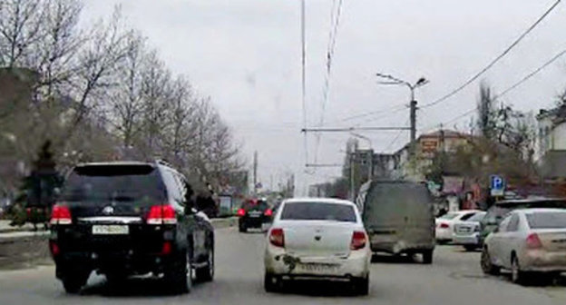 The security guard from the jeep of the convoy of the head of the republic Ramazan Abdulatipov beating the side mirrors of the surrounding cars with a police truncheon. Makhachkala, April 1, 2015. Screenshot of a video  by the user MishkaKG http://www.youtube.com/watch?v=GZzEzujUah8