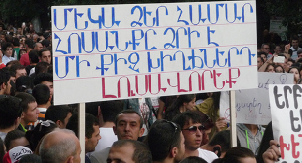 The participants of the protests against the decision to increase the electricity tariff. An inscription on the poster: "Electricity is free for you anyway, light up your souls a bit". Yerevan, June 29, 2015. Photo by Armine Martirosyan for the "Caucasian Knot"