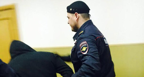 Police officer escorts one of the defendants in Boris Nemtsov murder case to the courtroom. Photo by Yulia Buslavskaya for the ‘Caucasian Knot’