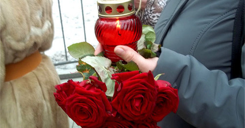 Participant of the funeral service for Boris Nemtsov holds candle and flowers. Moscow, March 3, 2015. Photo by Karina Gadzhieva for the "Caucasian Knot"