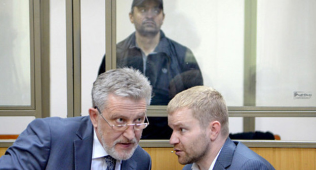 Advocates Postanyuk (to the left) and Khoroshilov hold a consultation during the court session. The defendant Murad Aliev is in the background, May 2015. Photo by Oleg Pchyolov for the "Caucasian Knot"