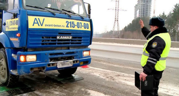 An inspector of the road-and-patrol service stops a truck. Photo: RFE/RL http://www.svoboda.org/ An inspector of the road-and-patrol service stops a truck. Photo: RFE/RL http://www.svoboda.org/
