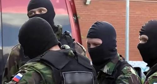 Law enforcers in masks. Screenshot of the video https://www.youtube.com/watch?v=ZsKHG3JRbso Law enforcers in masks. Screenshot of the video https://www.youtube.com/watch?v=ZsKHG3JRbso