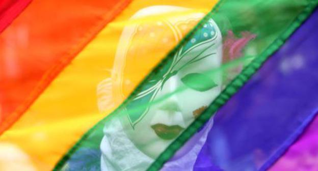A participant of the gay parade hidden beneath the flag of LGBT. Photo Reuters/S. Ravikumar A participant of the gay parade hidden beneath the flag of LGBT. Photo Reuters/S. Ravikumar