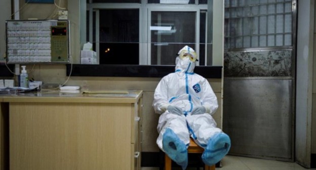 Health worker in a protective suit resting in a hospital in China's Wuhan, February 9, 2020. Photo: China Daily via Reuters Health worker in a protective suit resting in a hospital in China's Wuhan, February 9, 2020. Photo: China Daily via Reuters