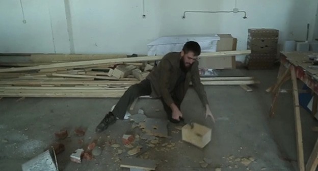 Chingiz Akhmadov smashes bricks and a wooden tabletop with a hammer, and also leaves noticeable dents on a metal bucket and a construction helmet. Screenshot: https://www.instagram.com/p/B9TZgN4IXm4/ Chingiz Akhmadov smashes bricks and a wooden tabletop with a hammer, and also leaves noticeable dents on a metal bucket and a construction helmet. Screenshot: https://www.instagram.com/p/B9TZgN4IXm4/
