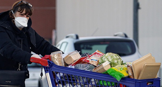 A woman in a medical mask buying food products. Photo: REUTERS/Pascal Rossignol A woman in a medical mask buying food products. Photo: REUTERS/Pascal Rossignol