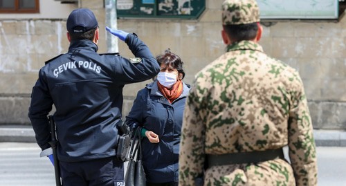 A police officer stops a woman in a street in Baku during the quarantine regime. Photo by Aziz Karimov for the "Caucasian Knot" A police officer stops a woman in a street in Baku during the quarantine regime. Photo by Aziz Karimov for the "Caucasian Knot"
