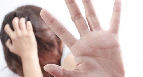 A woman shielding herself with her arm. Photo: Latina On a Mission https://flickr.com/ A woman shielding herself with her arm. Photo: Latina On a Mission https://flickr.com/
