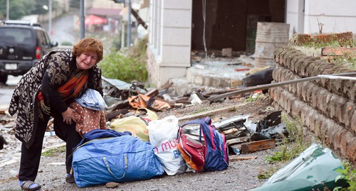 A woman rendered homeless gathers her belongings, October 6, 2020. David Kagramanyan / the information centre of NKR / PAN Photo / Reuters A woman rendered homeless gathers her belongings, October 6, 2020. David Kagramanyan / the information centre of NKR / PAN Photo / Reuters