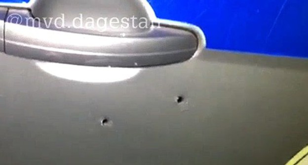 Bullet holes in a side door of the police car. Screenshot from video posted by the press service of the Ministry of Interior for Dagestan, https://05.мвд.рф Bullet holes in a side door of the police car. Screenshot from video posted by the press service of the Ministry of Interior for Dagestan, https://05.мвд.рф