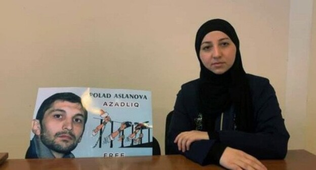 Gyulmira Aslanova sitting near a poster with Polad Aslanov's portrait. Photo: https://www.turan.az/ext/news/2020/12/free/Social/en/131347.htm Gyulmira Aslanova sitting near a poster with Polad Aslanov's portrait. Photo: https://www.turan.az/ext/news/2020/12/free/Social/en/131347.htm