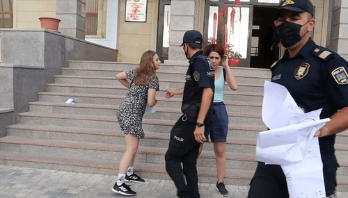 Policemen taking the posters away from the activists, Baku, August 4, 2021. Screenshot: Meydan TV, http://www.youtube.com/watch?v=Sm9Wy_44uWs Policemen taking the posters away from the activists, Baku, August 4, 2021. Screenshot: Meydan TV, http://www.youtube.com/watch?v=Sm9Wy_44uWs