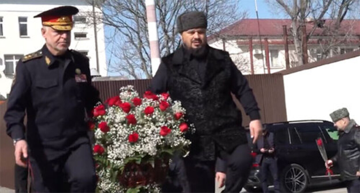 Ruslan Alkhanov, the Chechen Minister of Internal Affairs, and Abuzaid Vismuradov, Deputy Prime Minister of Chechnya, carry flowers to the memorial to the fallen police officers on the Defender of the Fatherland Day. February 23, 2022. Screenshot of the video by the Chechen Ministry of Internal Affairs https://www.instagram.com/p/CaUYCEtocad/ Ruslan Alkhanov, the Chechen Minister of Internal Affairs, and Abuzaid Vismuradov, Deputy Prime Minister of Chechnya, carry flowers to the memorial to the fallen police officers on the Defender of the Fatherland Day. February 23, 2022. Screenshot of the video by the Chechen Ministry of Internal Affairs https://www.instagram.com/p/CaUYCEtocad/