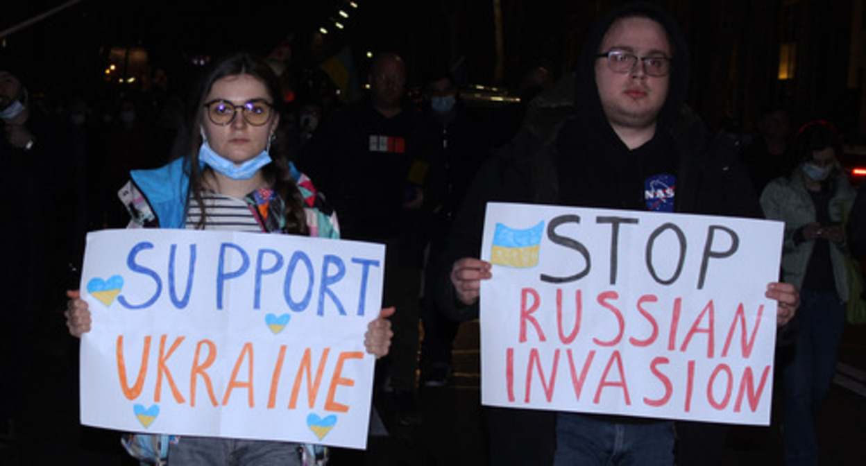 Protesters holding posters saying, "Support Ukraine" and "Stop Russian invasion." Protesters holding posters saying, "Support Ukraine" and "Stop Russian invasion."