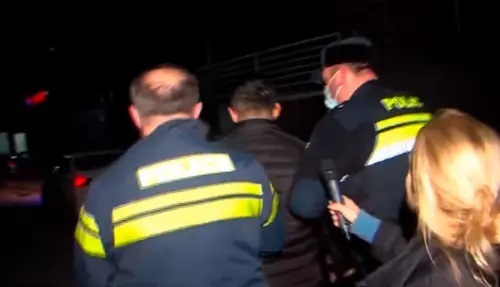 Police take away the attacker on journalists. Image made from video posted by Formula channel at: https://formulanews.ge/News/66843 Police take away the attacker on journalists. Image made from video posted by Formula channel at: https://formulanews.ge/News/66843