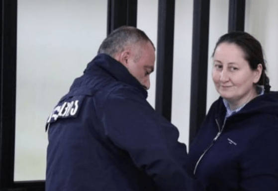 Mziya Amaglobeli (right) and a police officer. Screenshot of a photo by the Interpressnews posted on February 27, 2025, https://www.interpressnews.ge/ru/article/167011-advokat-mziia-amaglobeli-vypisana-iz-vivamed-i-trebuet-perevoda-v-penitentsiarnoe-uchrezhdenie-odnako-penitentsiarnaia-sluzhba-ee-ne-perevodit