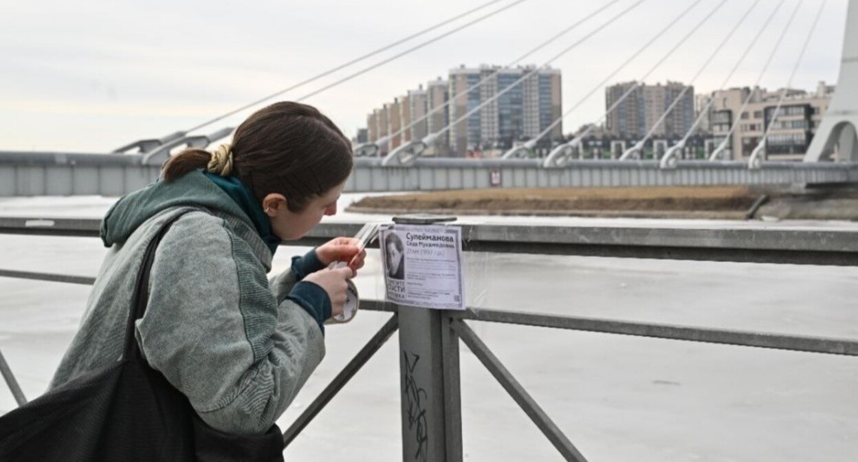 Elena Patyaeva sticks a leaflet on the bridge railing. St. Petersburg, March 8, 2025. Photo posted on Elena Patyaeva's Telegram channel https://t.me/helpseda/313