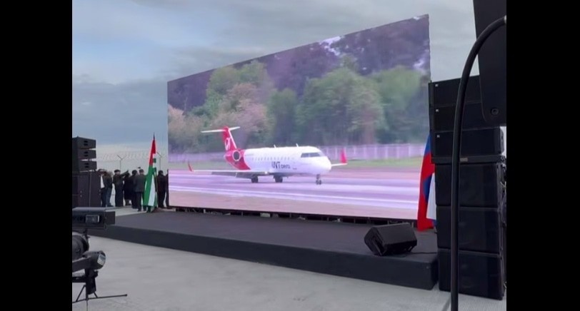 Arrival of a flight from Moscow, shown in online broadcast mode on a screen installed near the airport in Sukhum. May 1, 2025. Still from the video "Apsny 360°" https://t.me/aiashara/1892