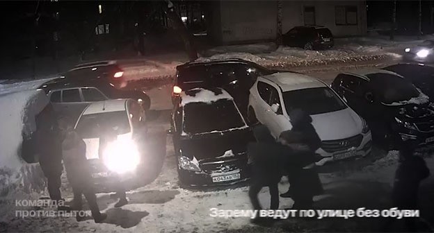 Zarema Musaeva is led to the car without shoes. Screenshot of the video https://t.me/no_torture/3642