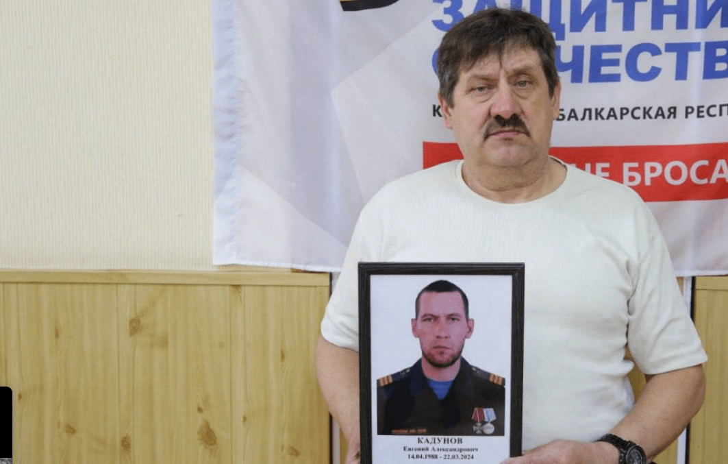 Father of Yevgeny Kadunov with his photo. Screenshot of the photo from the Telegram channel of the "Defenders of the Fatherland" foundation in Kabardino-Balkaria from 15.08.25, https://t.me/fond_ZO_kbr/7221