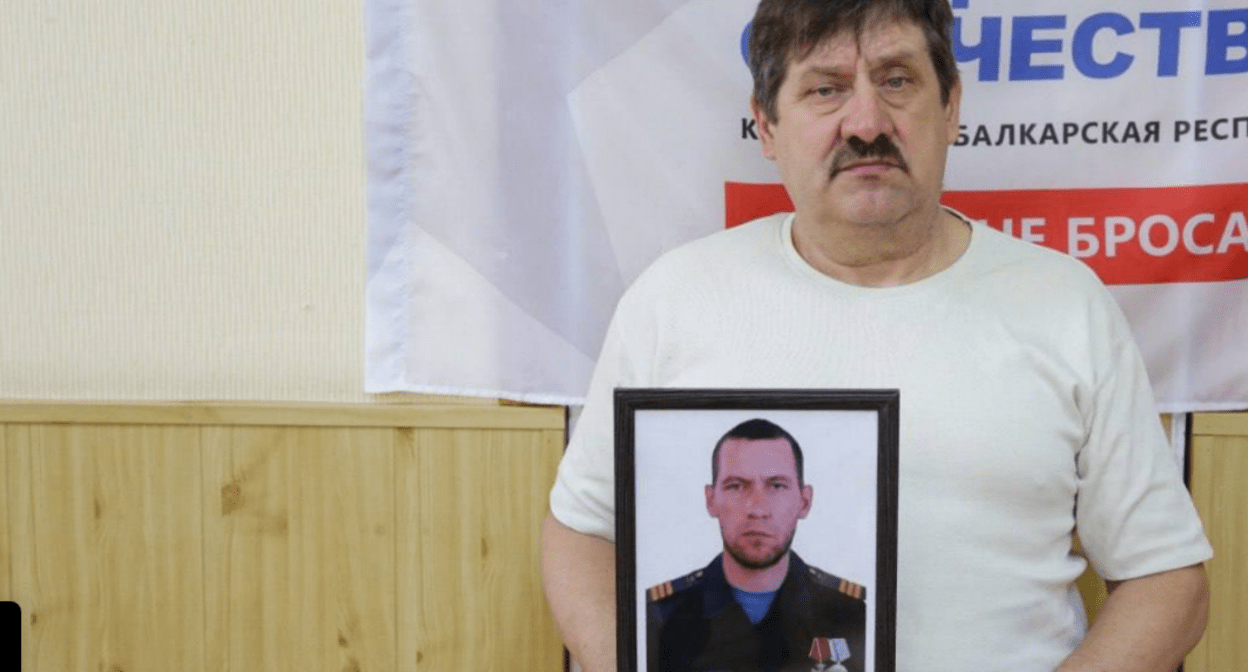 Father of Yevgeny Kadunov with his photo. Screenshot of the photo from the Telegram channel of the "Defenders of the Fatherland" foundation in Kabardino-Balkaria from 15.08.25, https://t.me/fond_ZO_kbr/7221