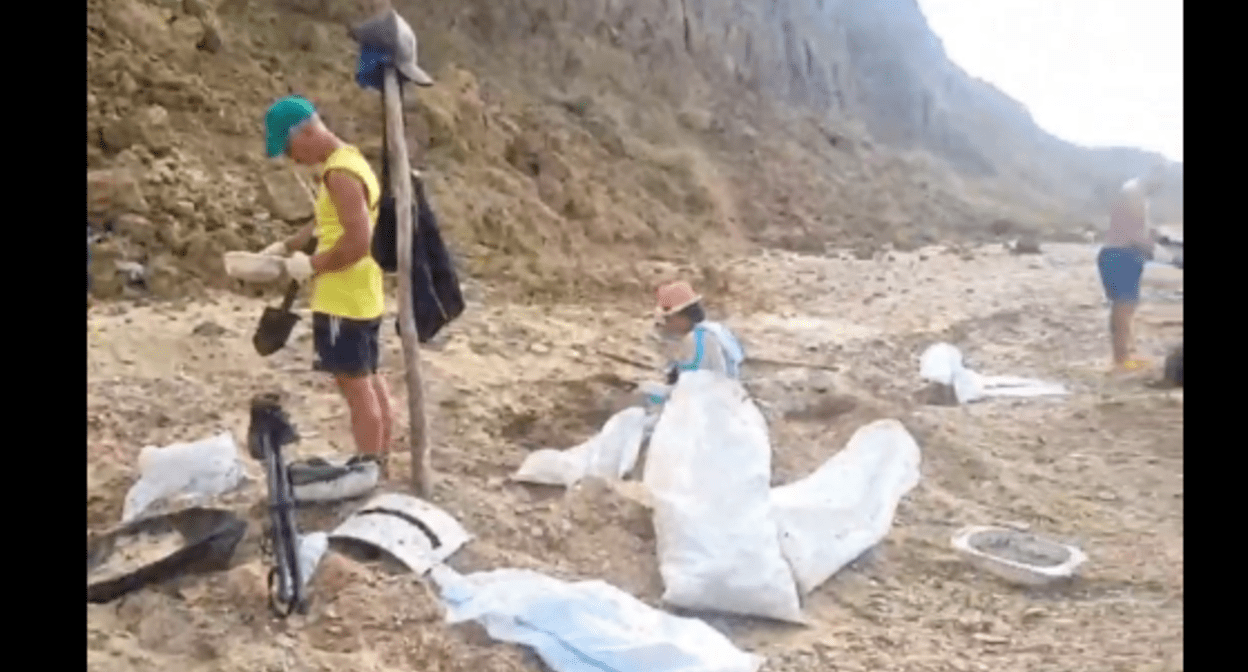 Volunteers clean up fuel oil on Cape Tuzla. Still frame from the video of the Dolphins headquarters from 09.09.25, https://t.me/shtab_delfin/1191