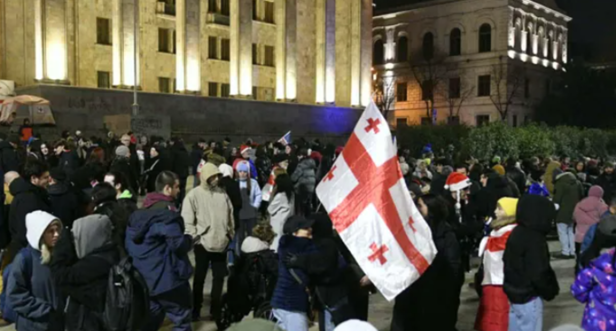 Protesters outside the Georgian Parliament. Screenshot from Interpressnews photo from December 18, 2025, https://www.interpressnews.ge/ka/article/857705-parlamenttan-saprotesto-akcia-mimdinareobs