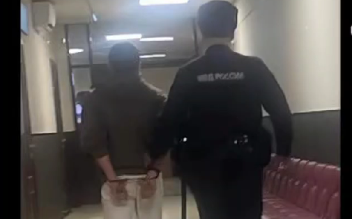 Roman Murdiev is led down an empty courtroom corridor. A still from a video in the possession of the "Caucasian Knot."