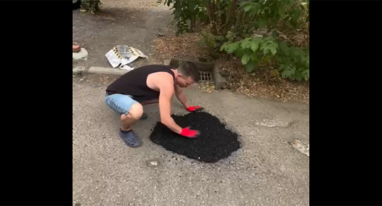 A resident of Krasnodar repairs the roadway in the courtyard. Frame from the video https://t.me/tipichkras/82566